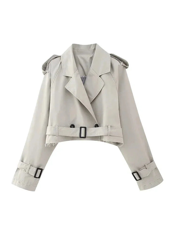 Gray cropped trenchcoat with buckle details, a stylish essential for any wardrobe. Drapes elegantly, perfect for layering in…