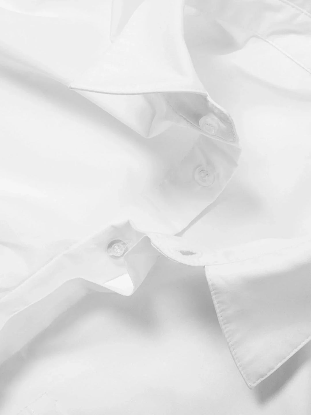 "Black cotton button-up shirt with cropped length and modern design details"