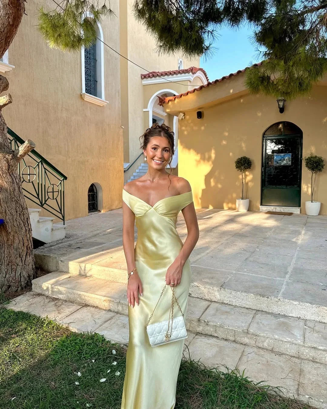 Cream off-shoulder maxi dress with clutch featuring Marvel design. Ideal for elegant occasions, made from quality material.