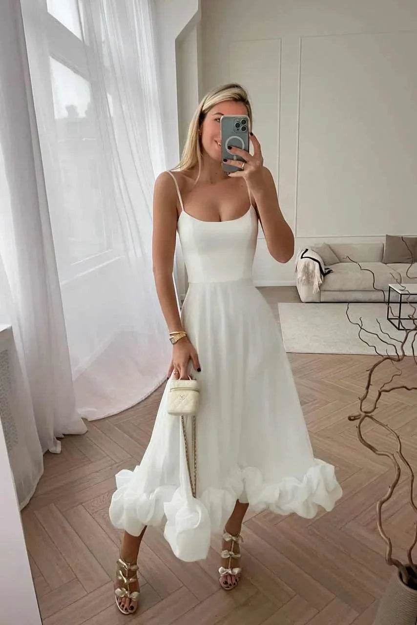 White midi dress with ruffle detail, made from lightweight cotton material. Features elegant design perfect for various…