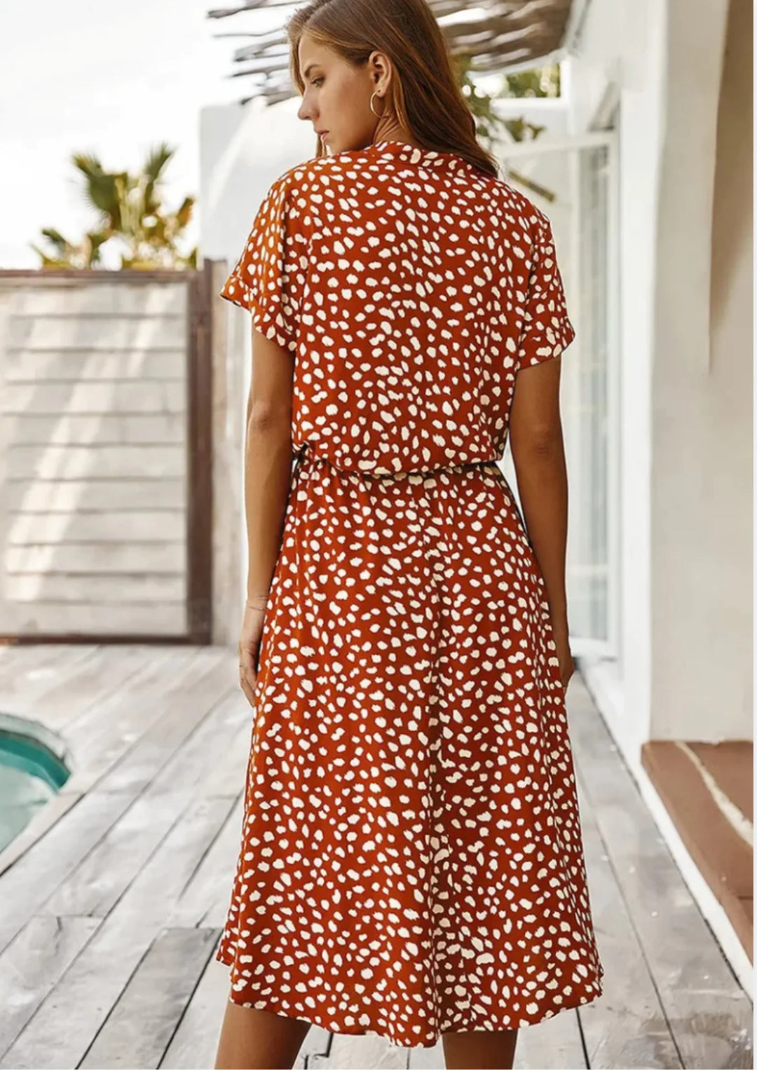 "Miani polka dot dress with waist tie, mid-length and V-neck design, perfect for a chic and playful look."