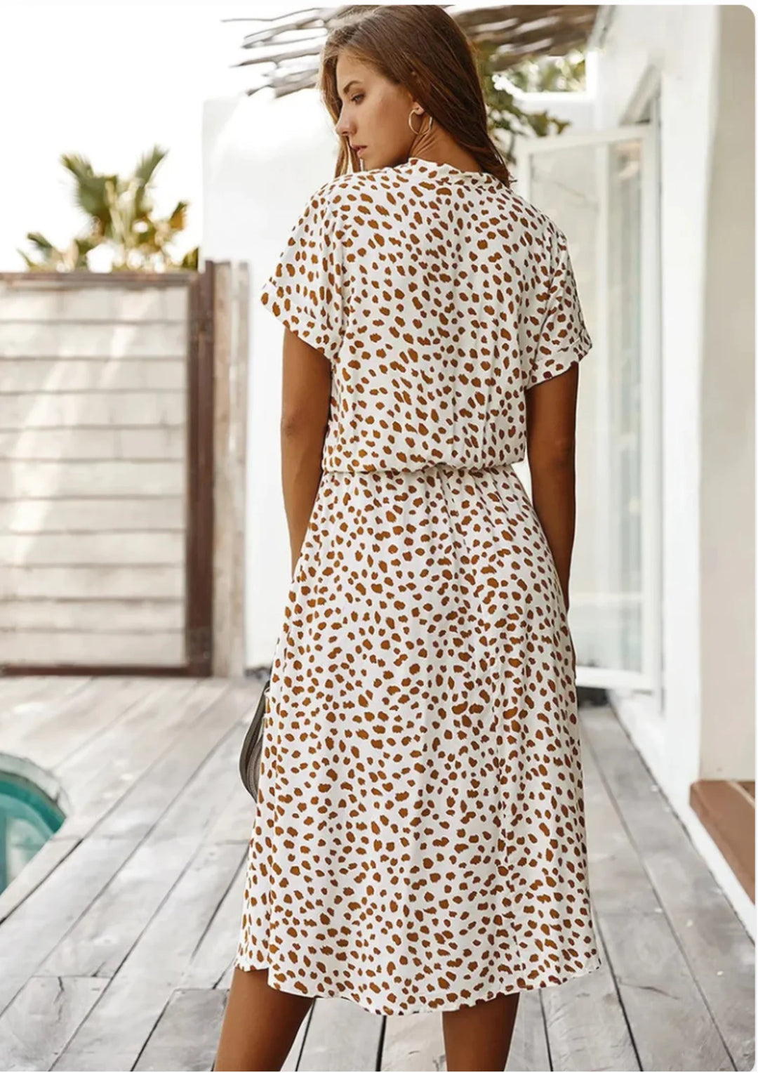 "Black and white polka dot midi dress with waist tie, perfect for casual or formal occasions."