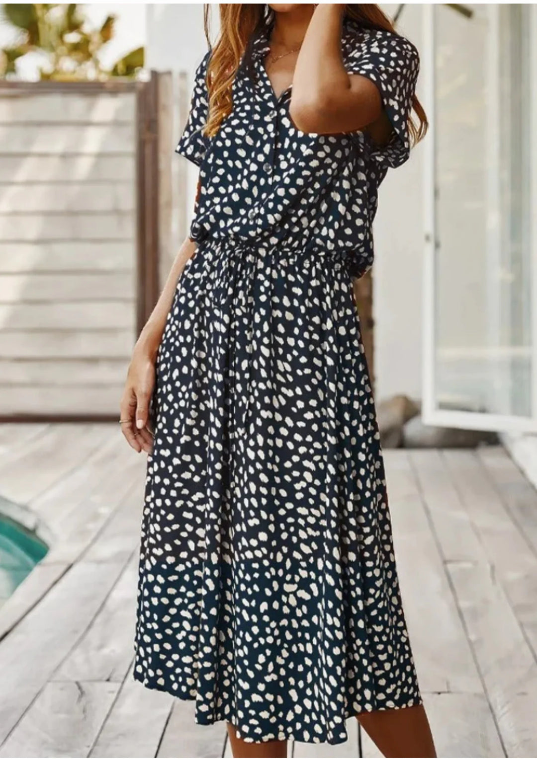"Black and white polka dot midi dress with waist tie, featuring a trendy design perfect for casual or semi-formal occasions."