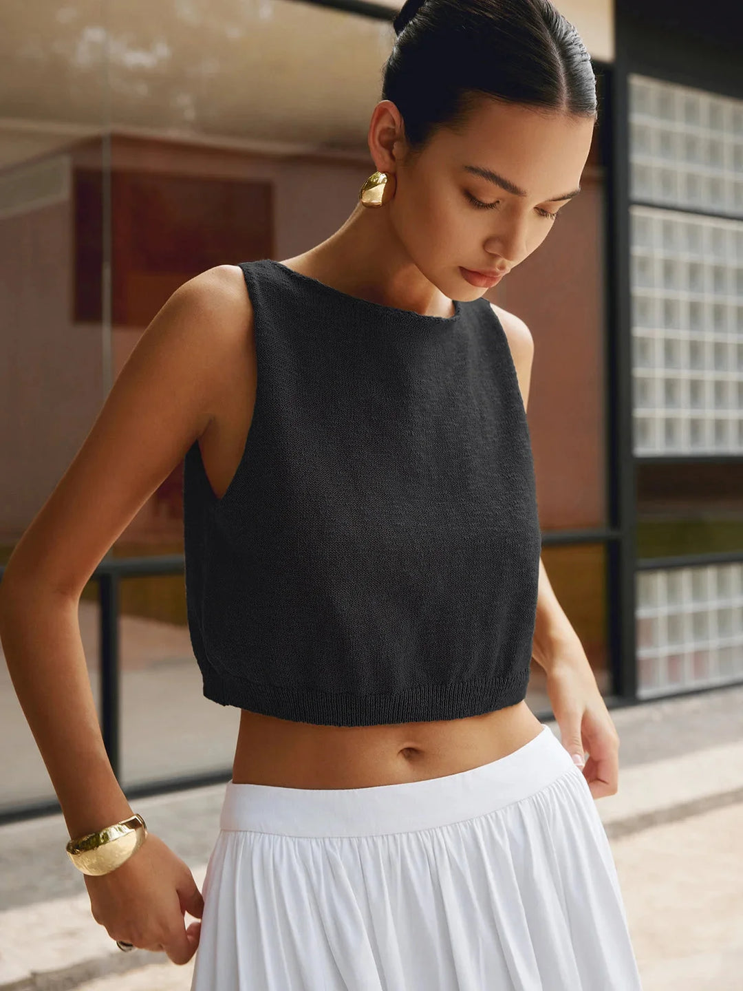 Black textured sleeveless crop top with a ribbed design, perfect for a chic and versatile look.