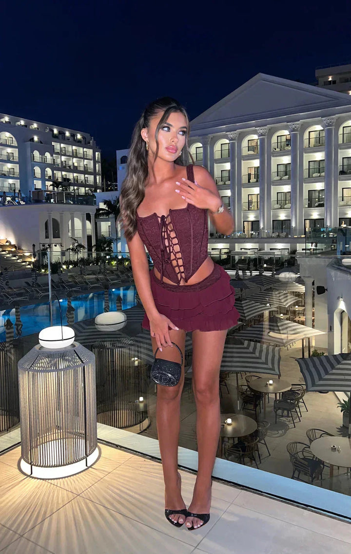 Cherry red lace bodice with ruffled mini skirt, a charming ensemble.