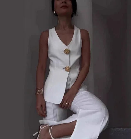 White sleeveless top and wide-leg pants set with decorative buttons in a lightweight and flowy material for a chic and…