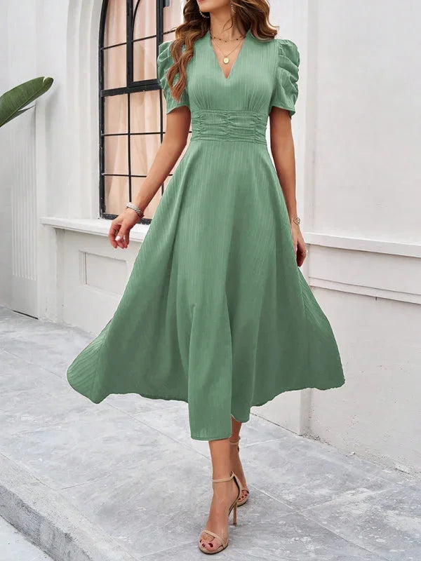 Green flowy midi dress with puff sleeves and V-neck. Soft and breathable fabric perfect for a casual yet chic look.