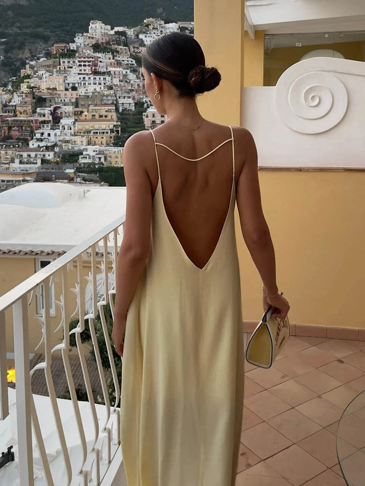 Naisha women's backless maxi dress with sleek straps, made of flowy fabric, perfect for a stylish summer look.