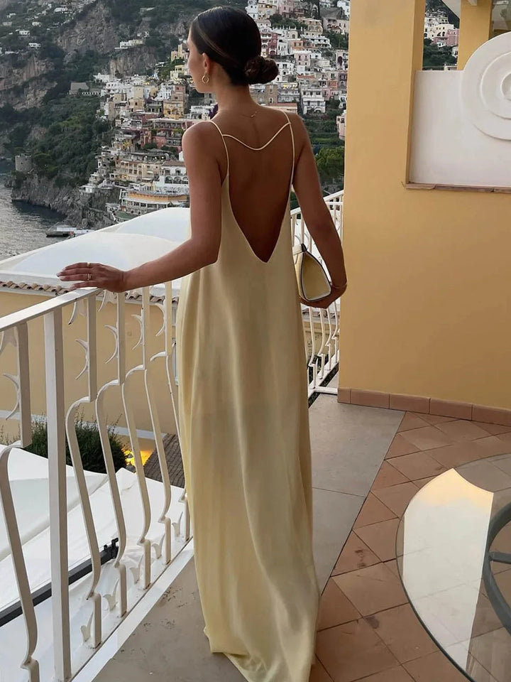 "Naisha backless maxi dress with sleek straps in soft, flowing fabric, perfect for a casual chic summer look."