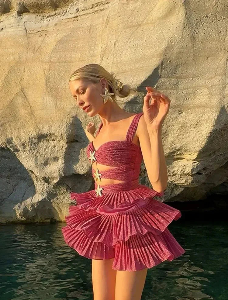 Pink ruffle dress with star details, shimmering fabric.