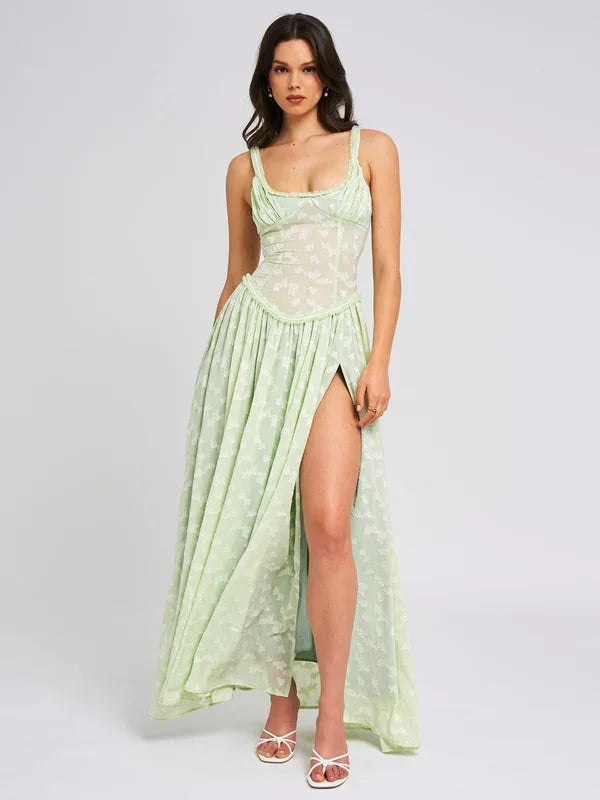 "Floral green maxi dress with side slit, made of flowy fabric, perfect for summer events and casual gatherings."
