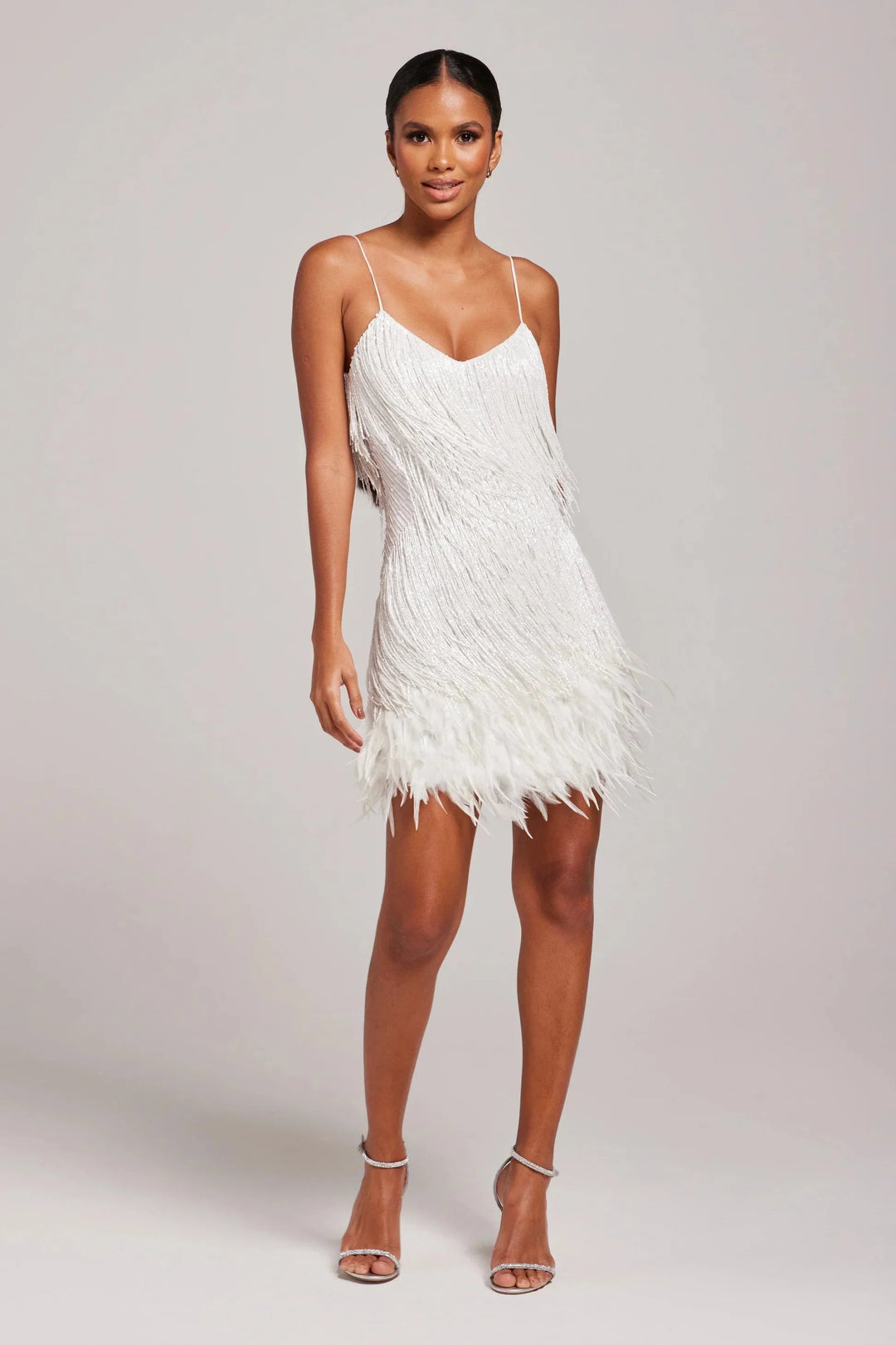 Black feathered mini dress with adjustable straps by Nazaret. Flattering design perfect for a night out or special occasion.