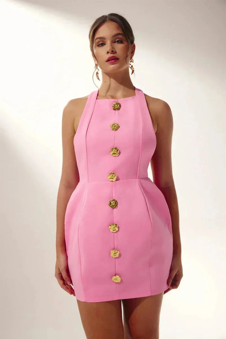 Pink halter mini dress with delicate floral embellishments. Perfect for summer with a playful and trendy design.