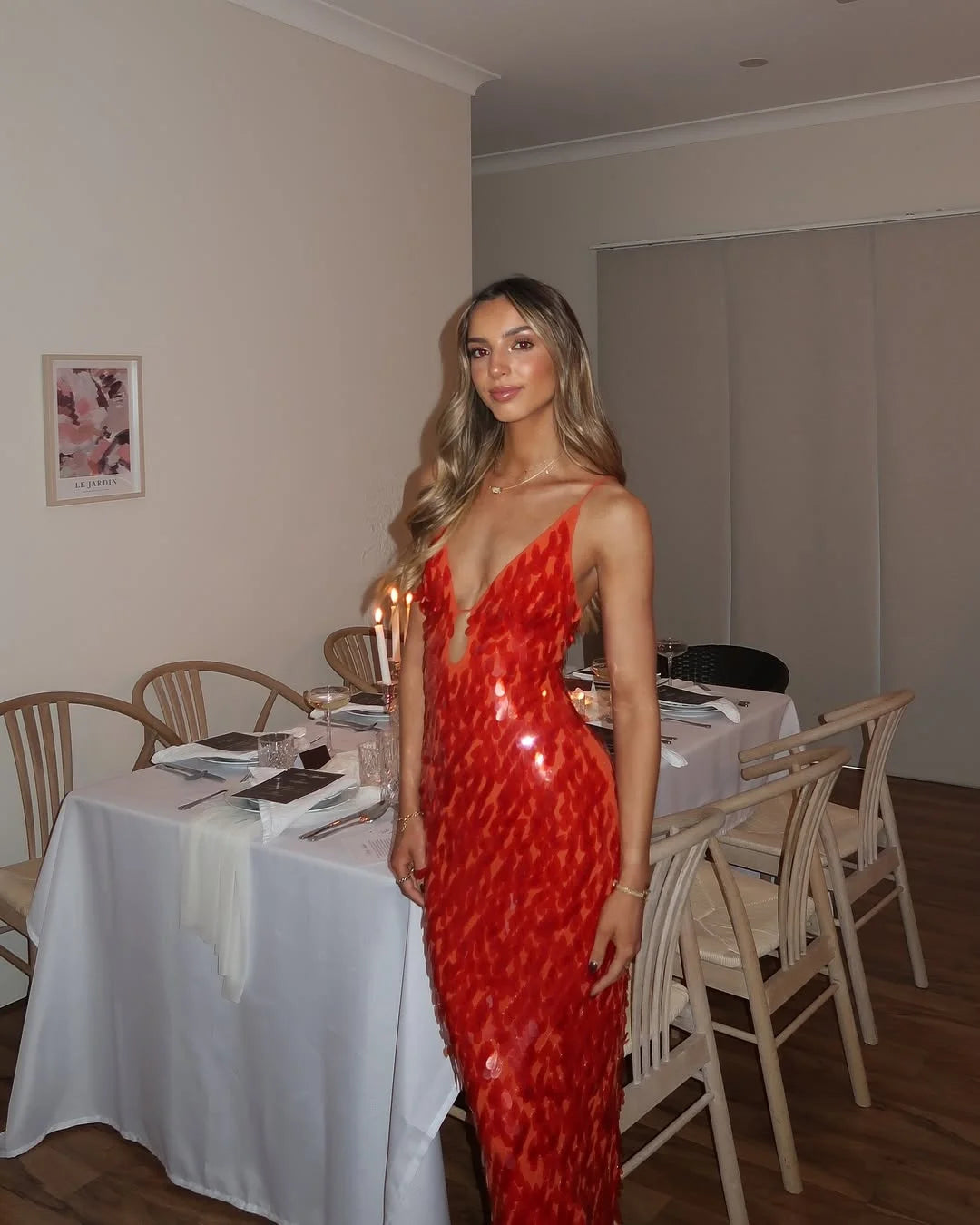 Red sequin maxi dress featuring a deep neckline, perfect for a glamorous event or night out.