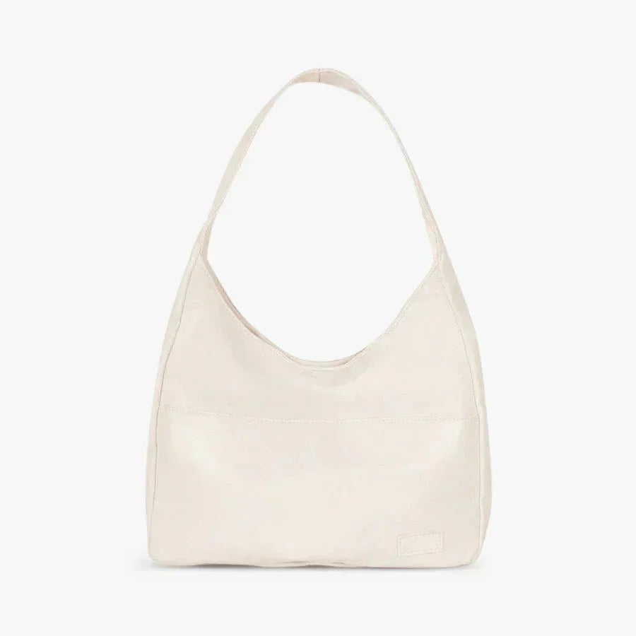 White Posie shoulder bag with sleek modern design, made of durable faux leather. Features adjustable strap, inner pockets,…
