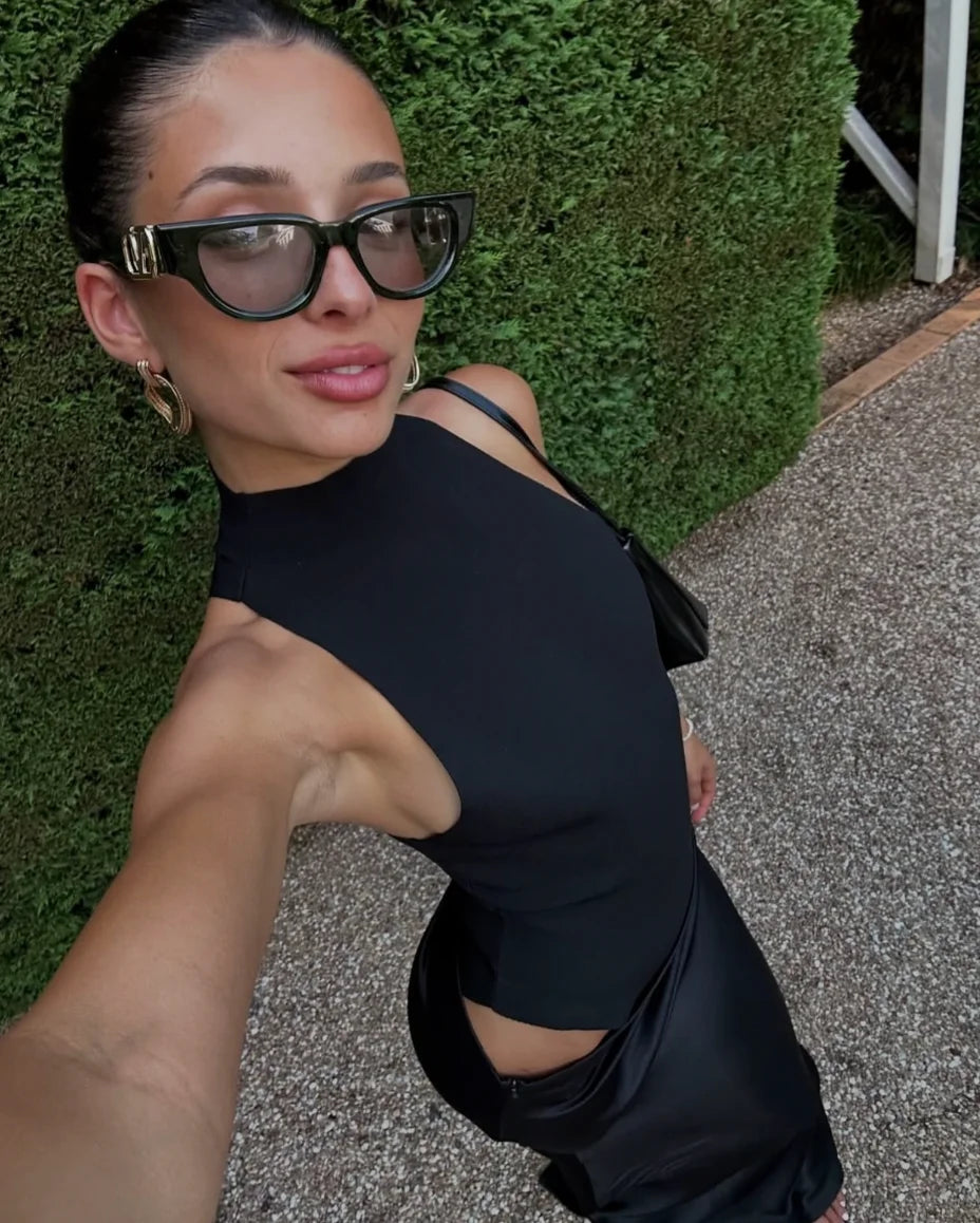 "Black halter neck maxi dress with cut-outs, made of flowy fabric, perfect for a chic summer look."