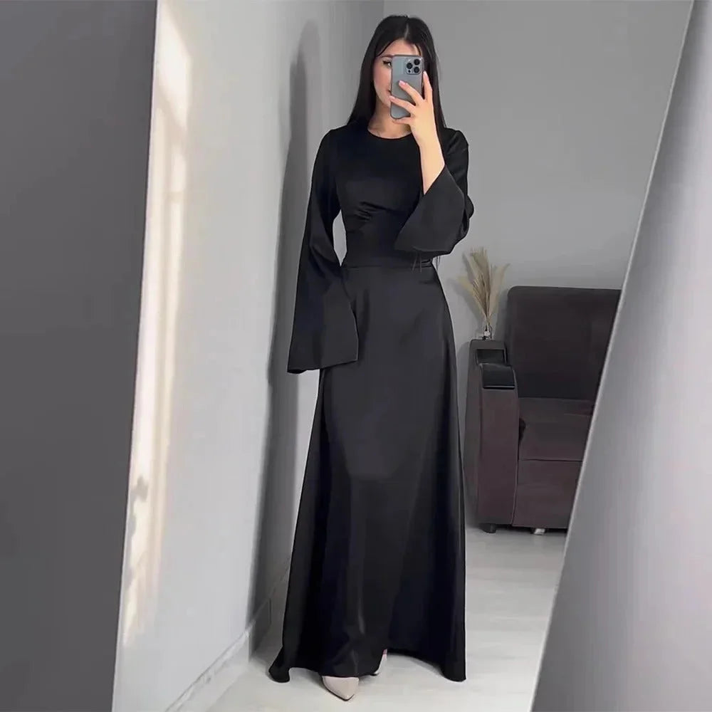 "Black floor-length dress with bell sleeves, V-neck, and intricate lace detailing for a sophisticated look."