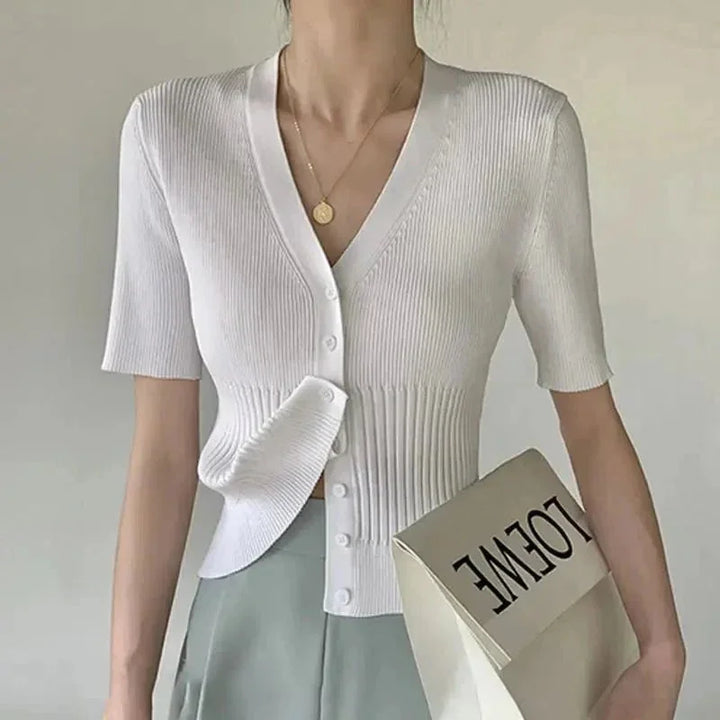White knit cardigan with button-front closure, fitted silhouette, and ribbed detailing. Perfect layering piece for casual or…
