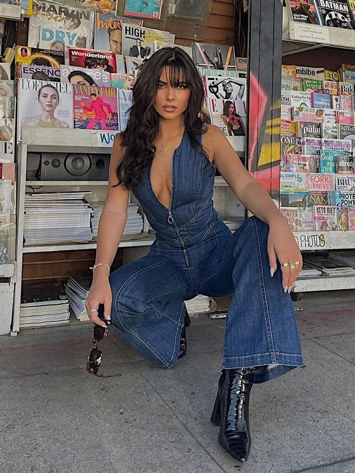 Sleeveless blue denim jumpsuit with zipper, featuring a flattering fit and functional design for a versatile and trendy look.
