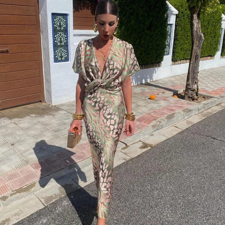 Green V-neck wrap dress with intricate prints, made of breathable and lightweight fabric.