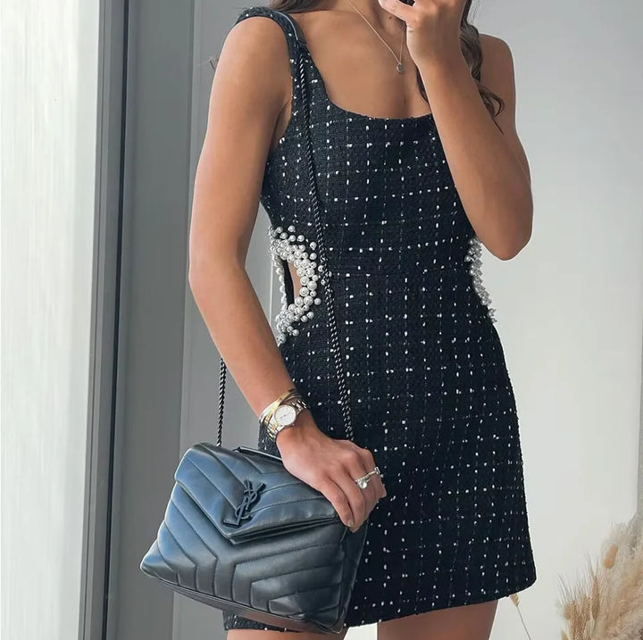"Black dress with beaded detailing and pearl accents, perfect for a sophisticated look at any event."