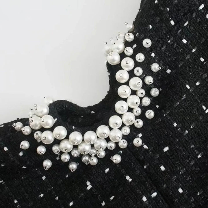 Beaded black dress with pearl accents, exquisite and elegant evening attire for formal events.