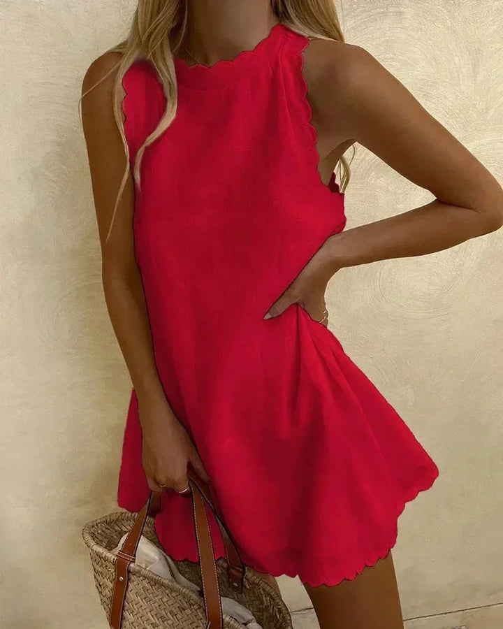 Red sleeveless dress with scalloped hem, made of lightweight textured fabric. Perfect for a chic and elegant look.