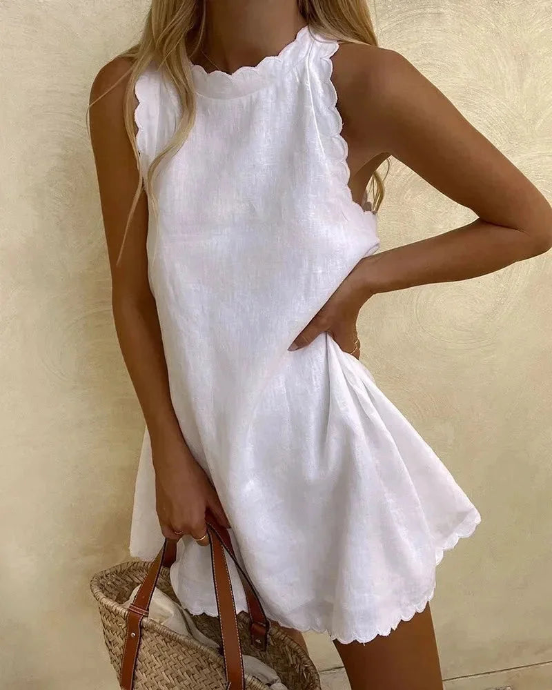 White sleeveless dress with scalloped hem, perfect for summer. Made with lightweight and breathable fabric, ideal for casual…