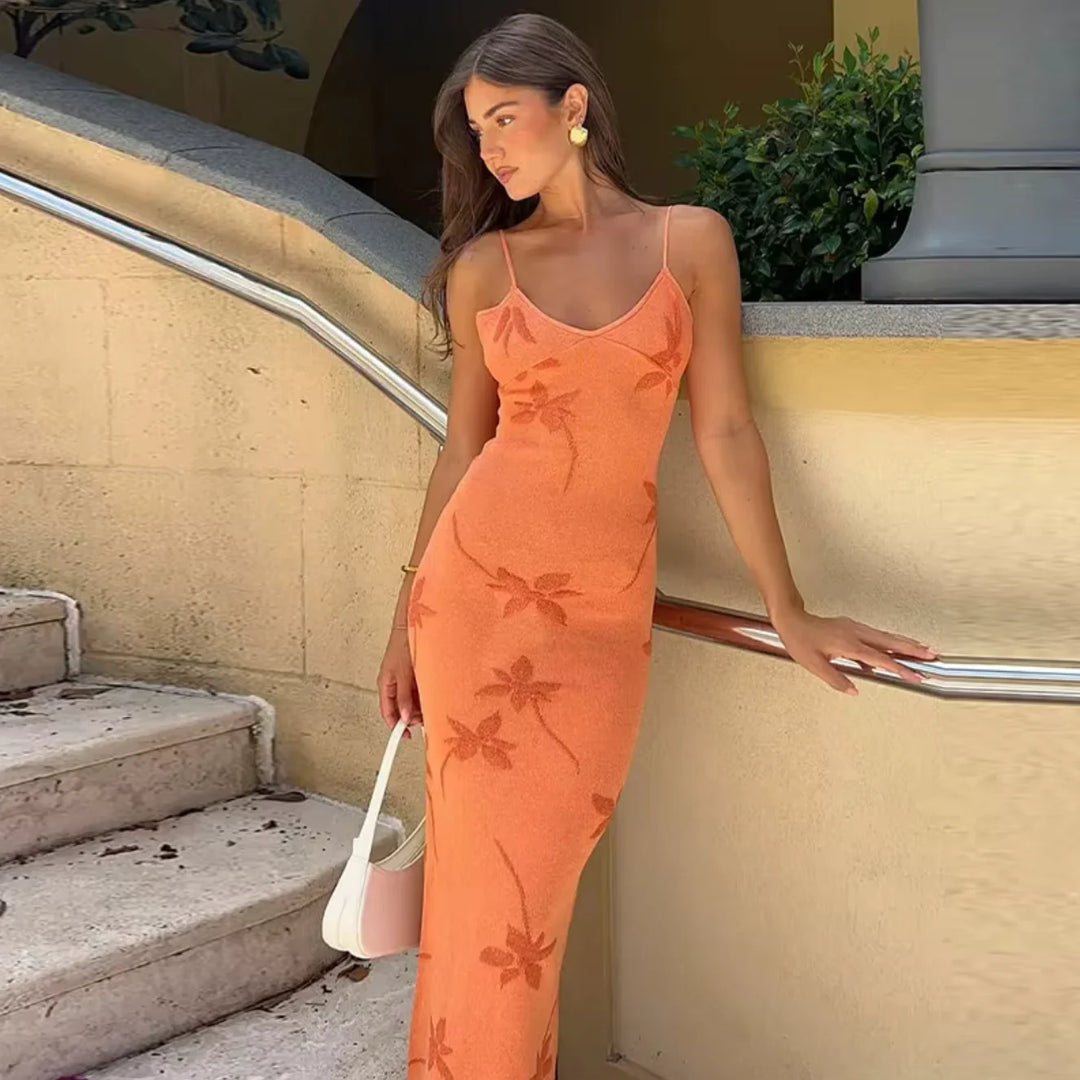 "Maxi dress in coral shade with floral patterns, perfect for a breezy summer day out."