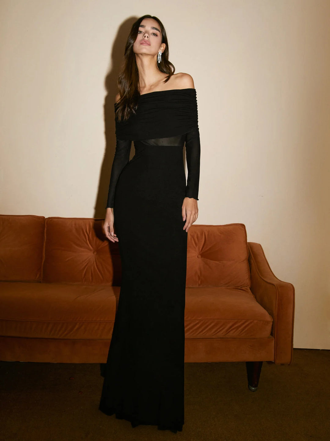 Black off-shoulder mesh sleeve dress made from fitted fabric, perfect for an elegant evening out or formal event.