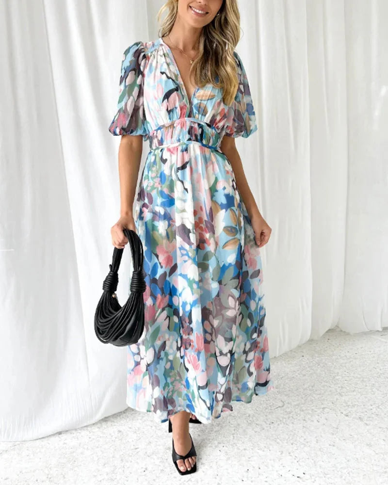 Blue floral maxi dress with long sleeves made of lightweight chiffon fabric, featuring a delicate floral pattern and flowy…