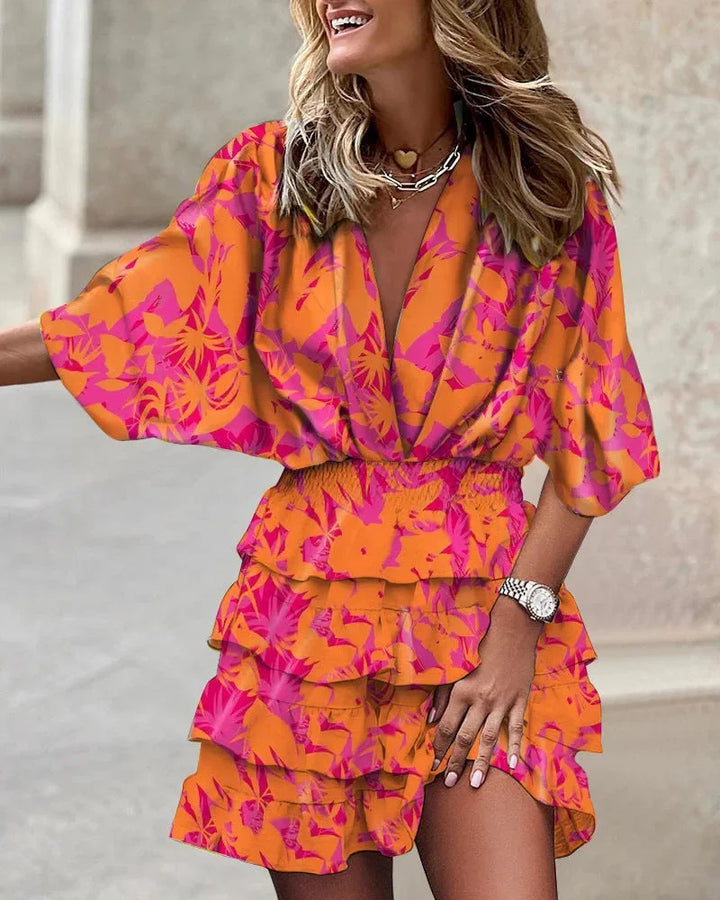 "Orange abstract mini dress with tiered design, vibrant colors, and flowy silhouette, perfect for a playful and eye-catching…