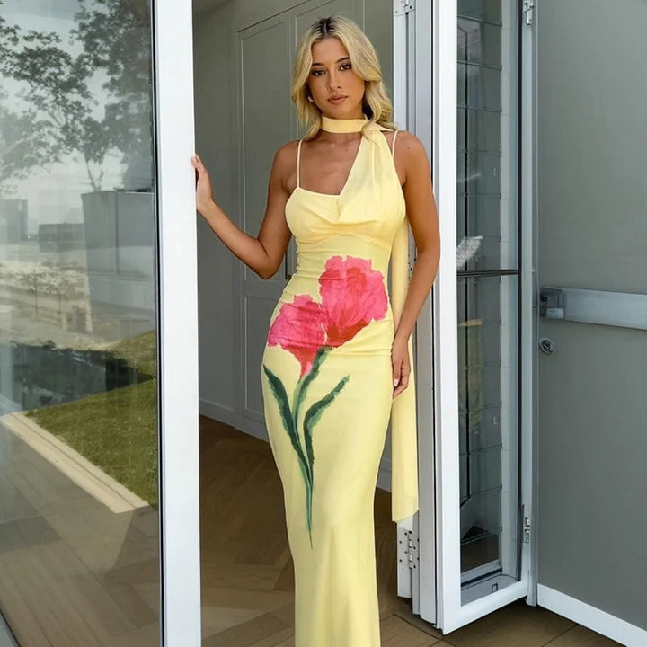 Yellow floral maxi dress with halter neck featuring a vibrant floral pattern, flowy silhouette, and halter neckline for a…