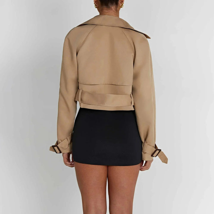 Sevynn trench coat in a modern cropped design, showcasing a sleek silhouette, structured collar, and belted waist in a…