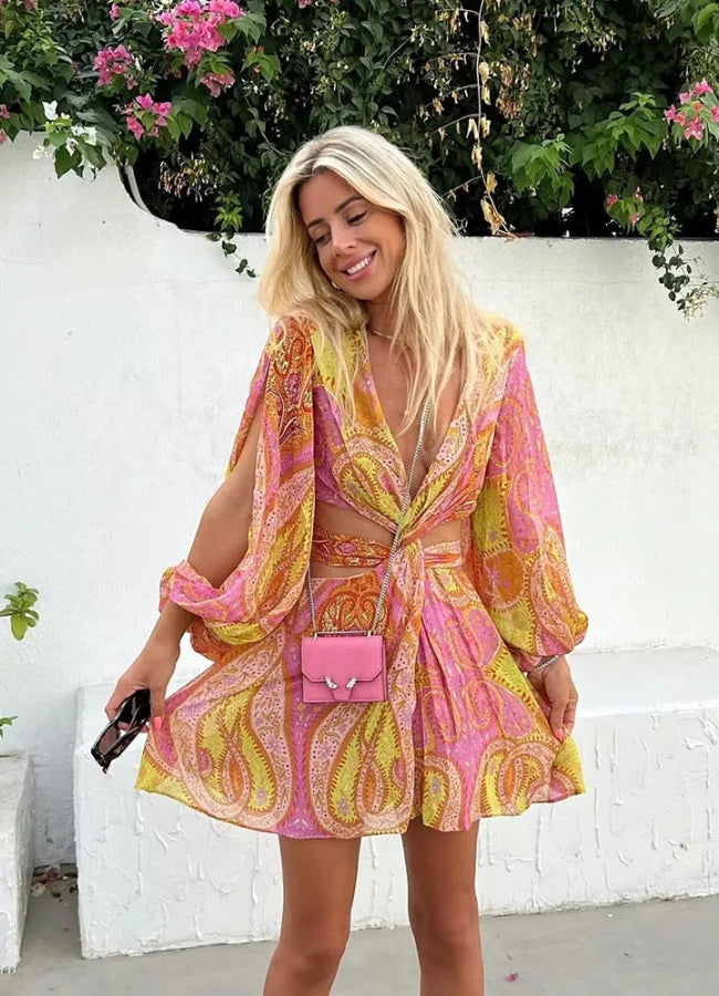 Pink and yellow patterned mini dress with V-neck, perfect for a casual yet stylish look.