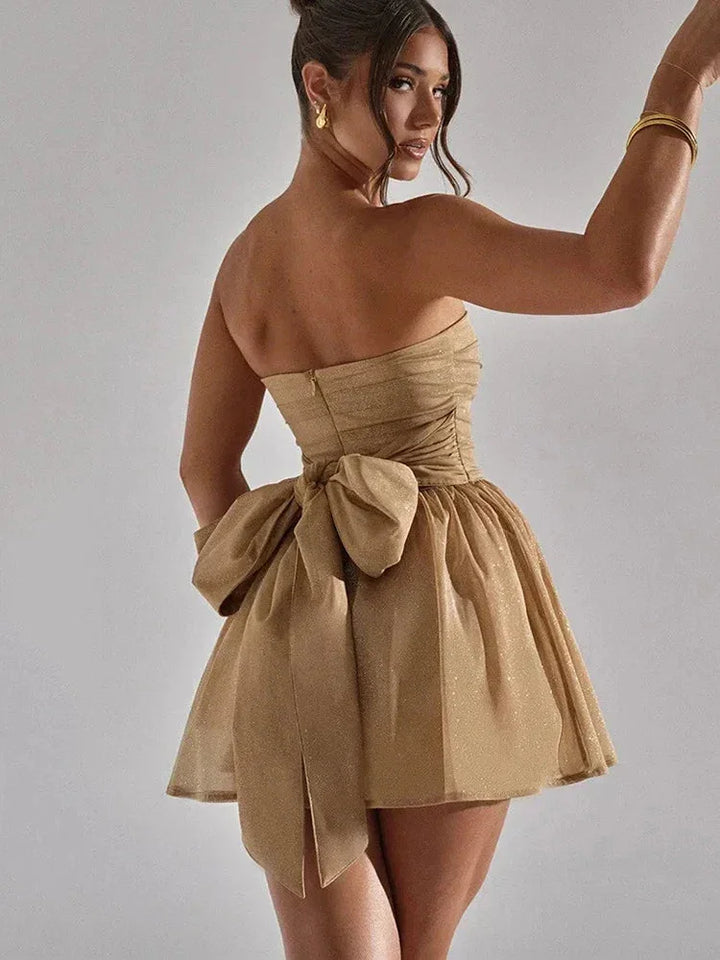 Gold mini dress with pleated design, featuring shimmering glitter accents.