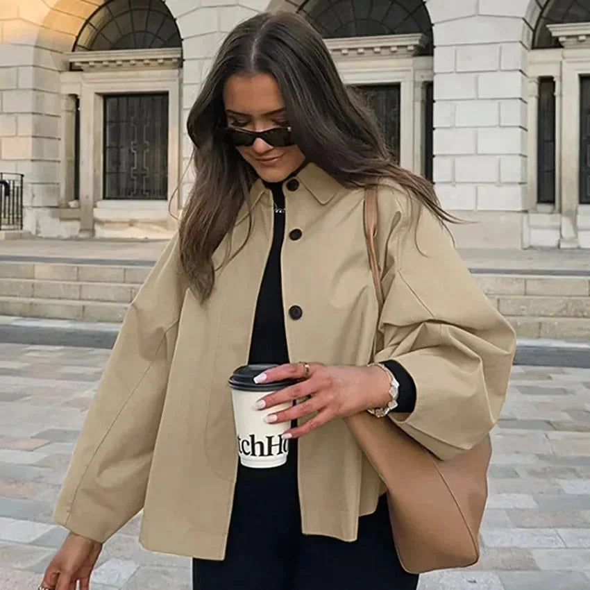 Beige oversized trench coat with button-up front, featuring a sleek design and high-quality fabric for a chic and…