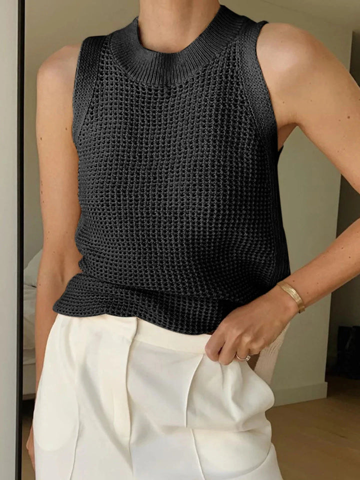 "Sleeveless black knit top for women, made of breathable material with a sleek and versatile design."