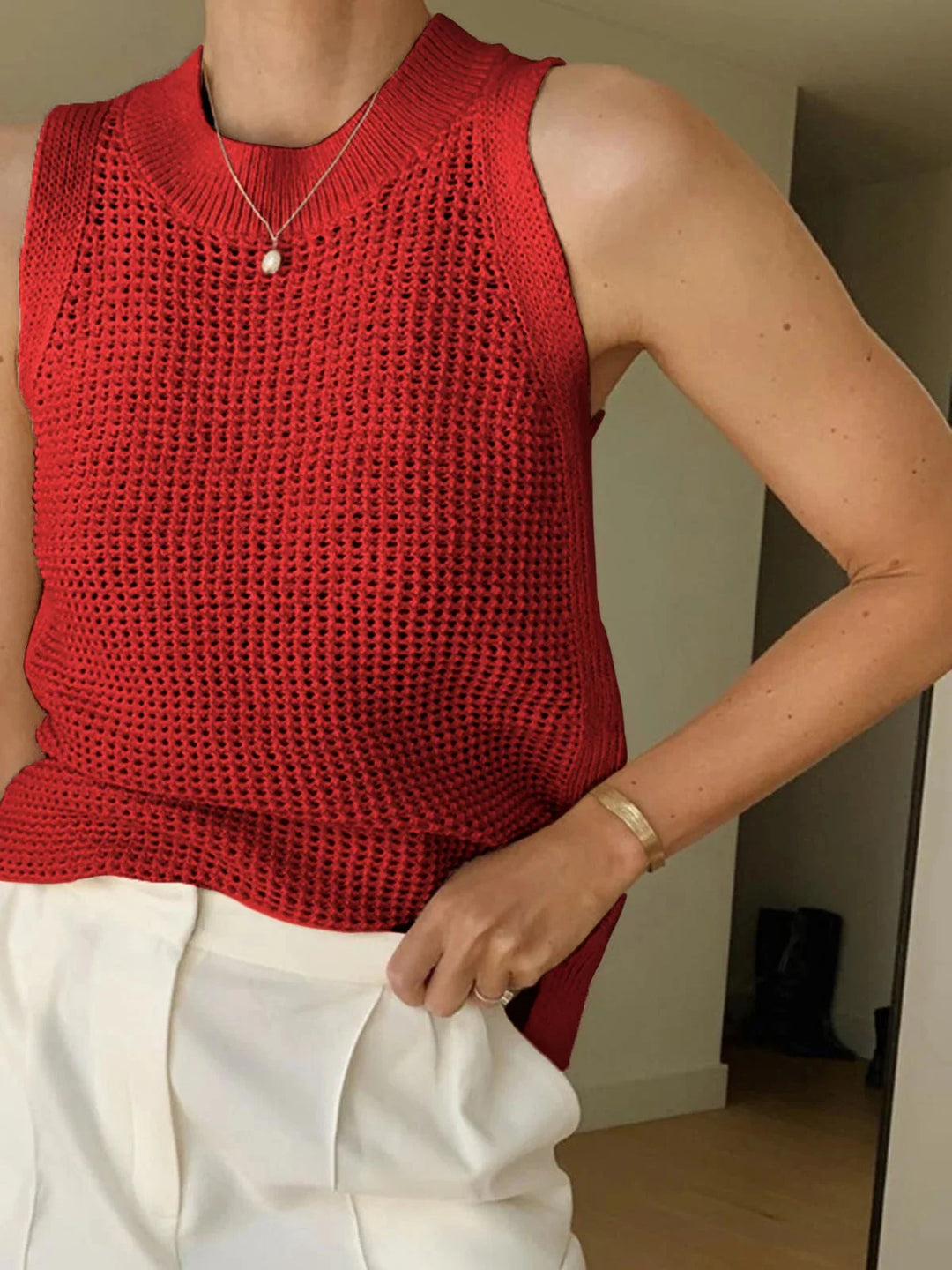 "Sleeveless red knit top in breathable fabric for summer, featuring a stylish design perfect for casual outings."