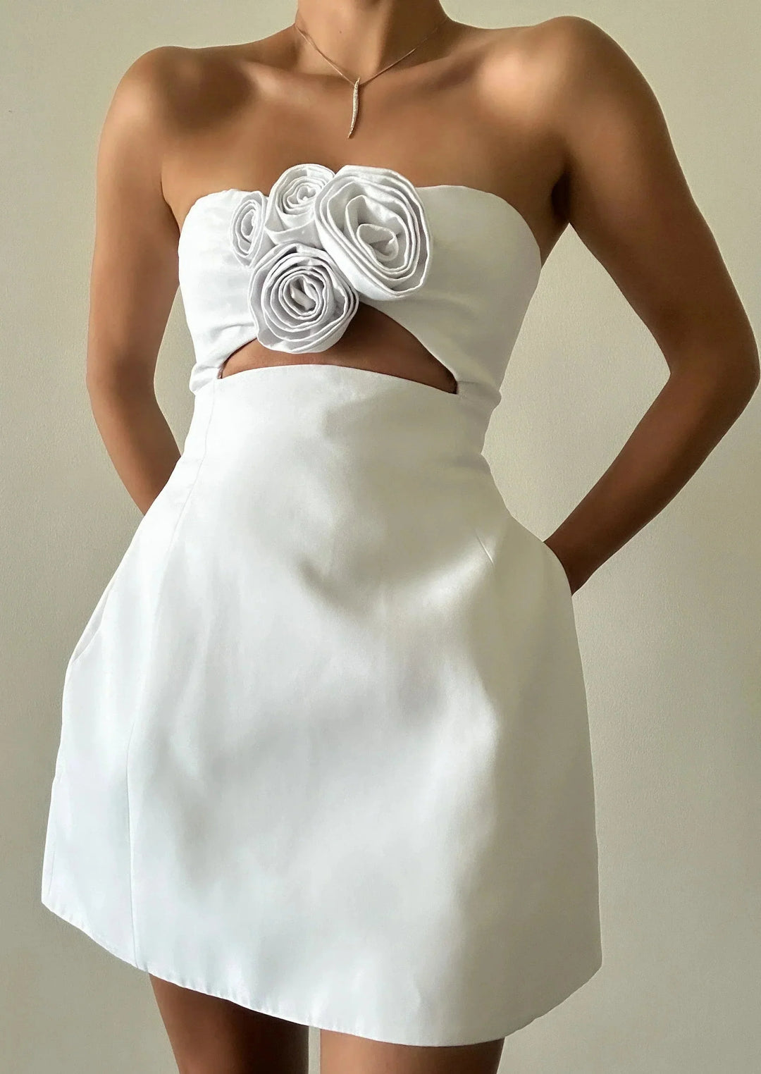 White floral mini dress with cutout detail, perfect for a breezy summer look. Made of lightweight fabric for comfort and…