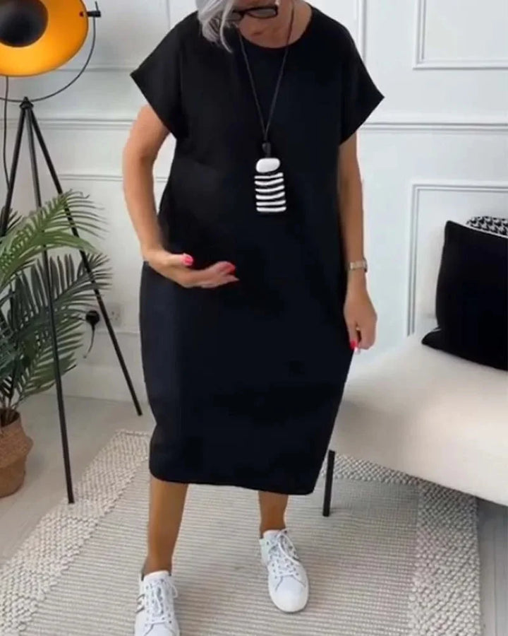 "Black knee-length dress with v-neck and loose silhouette, made from soft cotton blend for a comfortable and stylish fit."