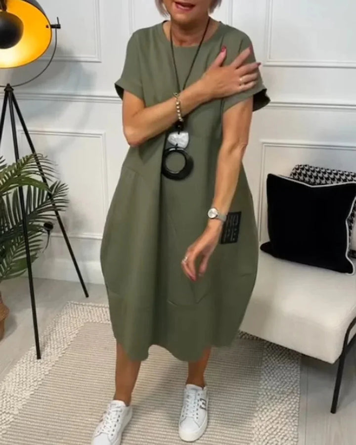 "Black cotton midi dress with a relaxed fit and trendy design, perfect for everyday wear."
