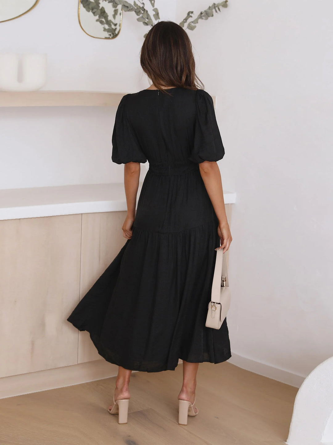 "Black midi dress with V-neck and elastic waist, a chic option for any occasion"
