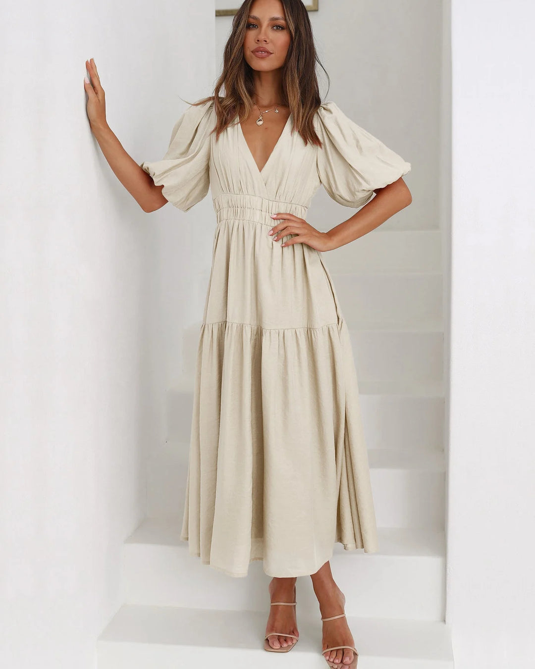 Cream V-neck midi dress with elastic waist, perfect for any occasion. Features trendy design in a comfortable fabric.