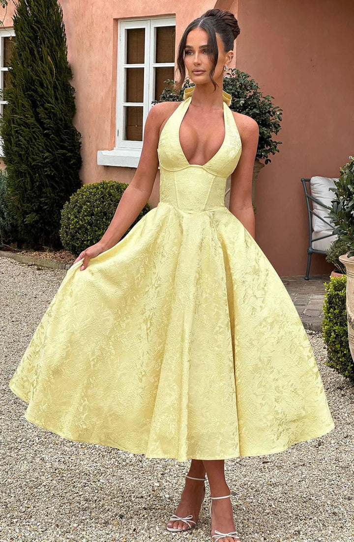 Sunny yellow halter dress with pleated skirt, perfect for summer days.
