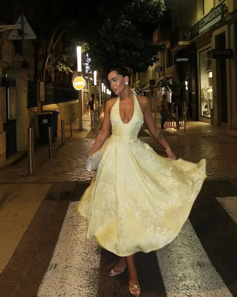 Yellow halter dress with pleated skirt, made from soft cotton blend fabric, perfect for summer outings and casual chic looks.