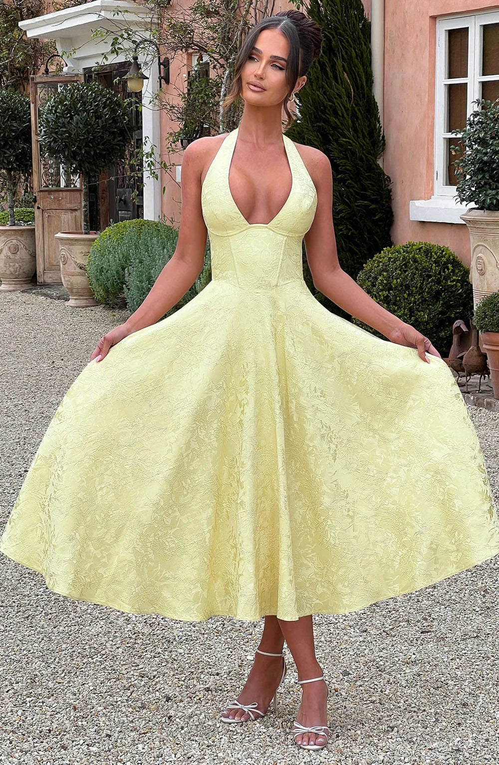 Yellow halter dress with pleated skirt made of soft cotton blend. A-line silhouette with tasteful detailing for a chic look.