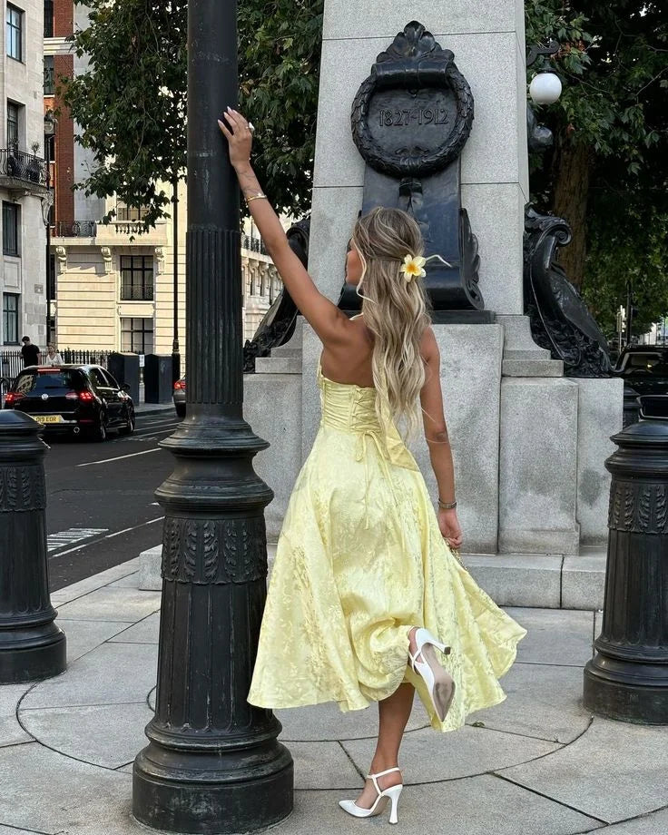 Yellow halter dress with pleated skirt, perfect for summer days. Made of soft, flowy fabric with a flattering silhouette.