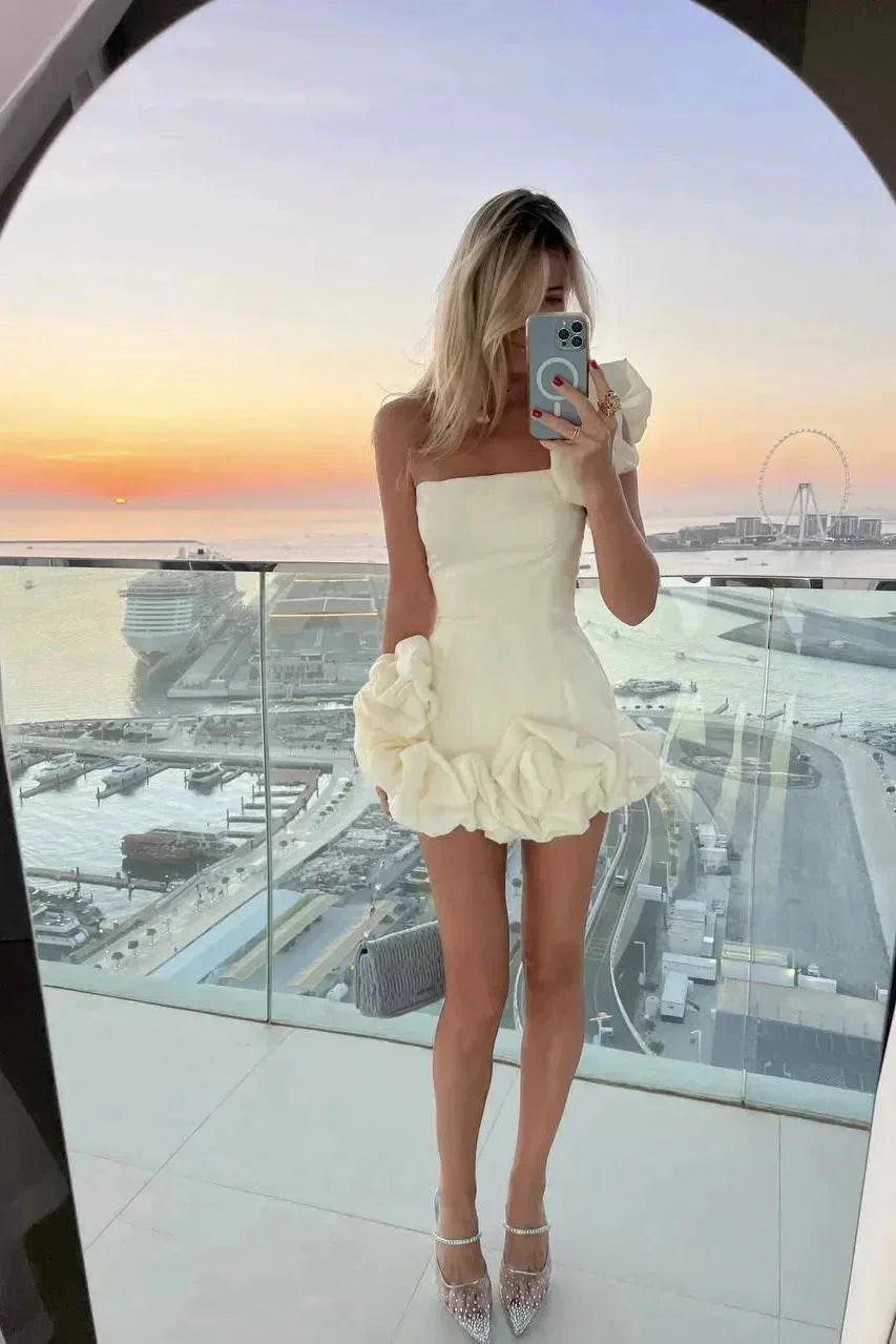 "Black strapless mini dress with ruffled detailing and elegant design, perfect for a special occasion."