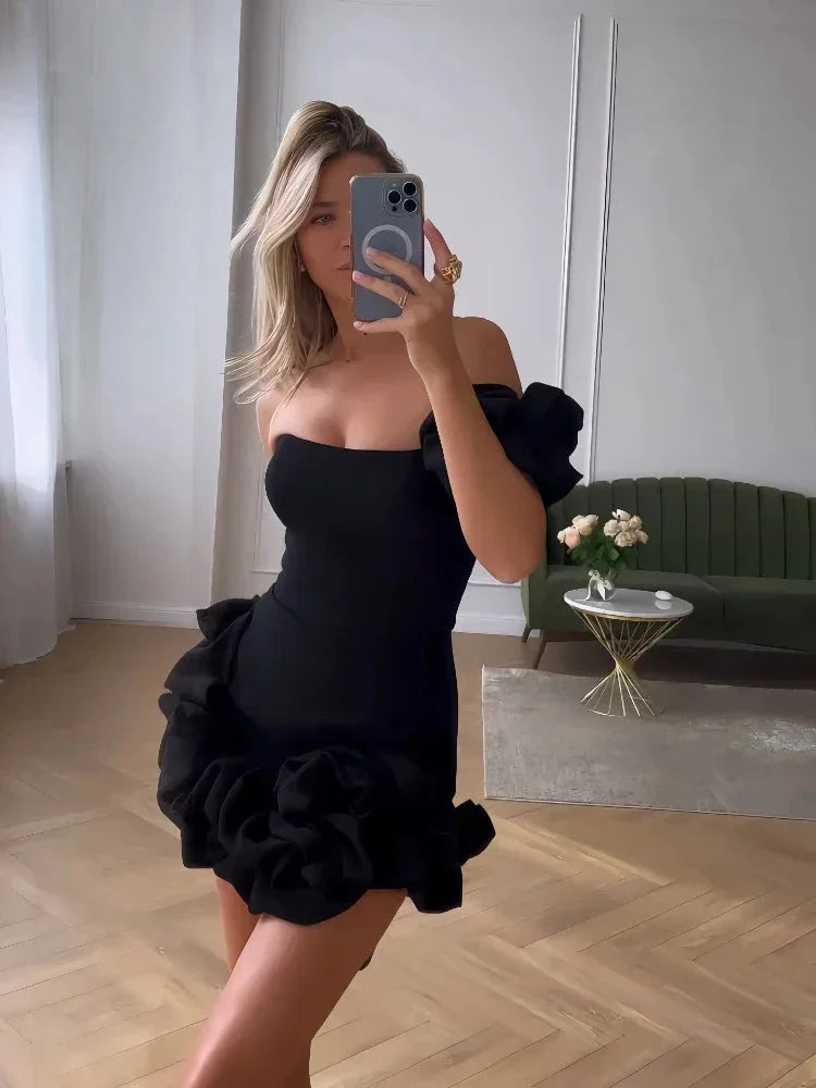 Black strapless ruffled mini dress with sweetheart neckline and tiered skirt. Made of lightweight fabric with a flattering…